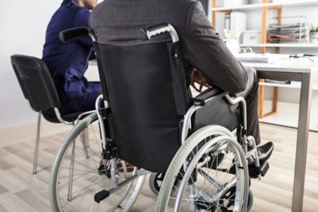 man in a suit in a wheel chair at a desk