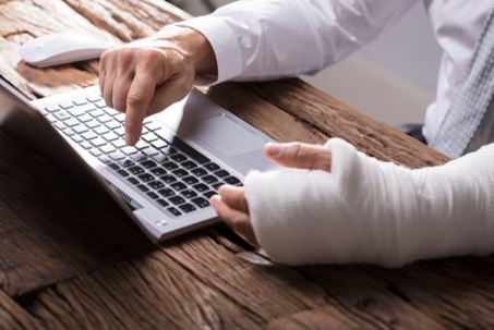 man in a cast on his laptop
