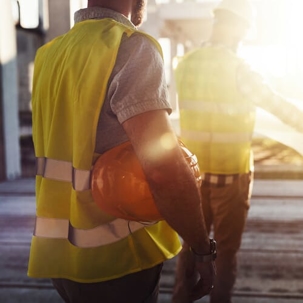 Construction worker with hard hat under his arm